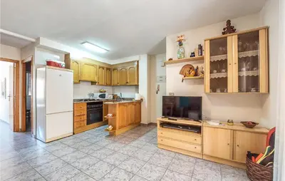 a kitchen with wooden cabinets and a white refrigerator at 2 Bedroom Nice Apartment In Moncofa in Moncófar