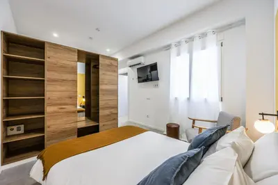 a bedroom with a large white bed and a tv at Amazinn Valencia Cabanyal 2C in Valencia