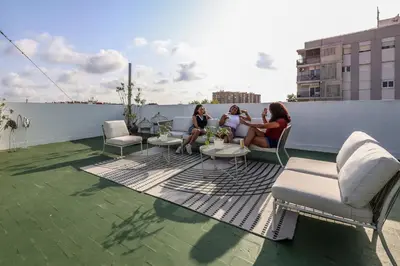 three women sitting on top of a roof at Amazinn Valencia Cabañal 3A in Valencia