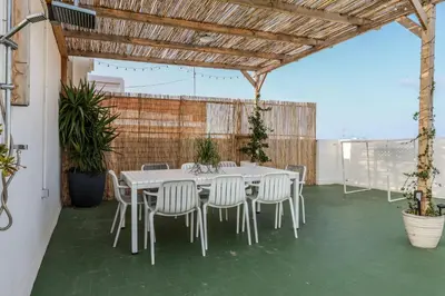 a white table and chairs under a wooden roof at Amazinn Valencia Cabañal 3A in Valencia