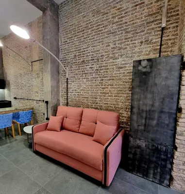 a couch in a room with a brick wall at cactus loft Ruzafa in Valencia