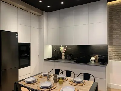 a kitchen with white cabinets and a table and chairs at La Reina Beach rooms in Valencia