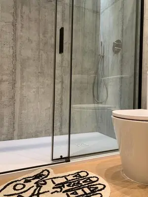 a bathroom with a shower and a rug on the floor at La Reina Beach rooms in Valencia