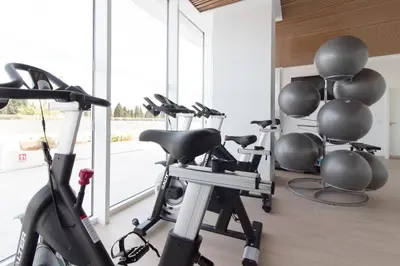 a gym with cardio equipment in a room with windows at Moderno apartamento con 2 terrazas en Gran Canet by Global Vacacional in Canet de Berenguer