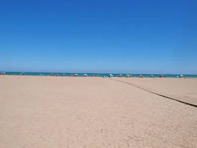 a sandy beach with umbrellas and the ocean at Apartamentos Las Ciencias Studio Y in Valencia
