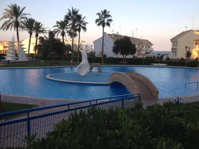 a statue of a swan in the middle of a swimming pool at Modern Penthouse-duplex Facing The Sea in La Torre