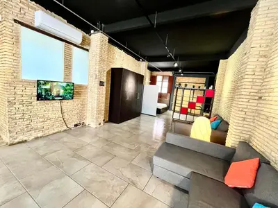a living room with a couch and a tv on a brick wall at IY Loft 4 - Open Plan Garage Style - Up to 4 people in Valencia