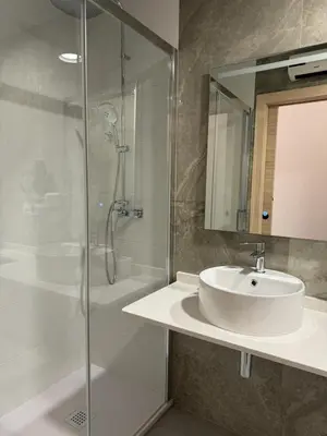 a bathroom with a sink and a glass shower at Almar 52 Suites in Valencia