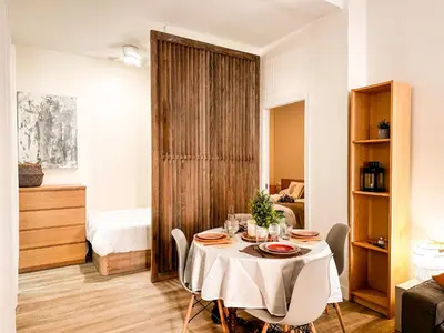 a dining room with a table and a bedroom at apartamento muy próximo a Valencia in Burjasot