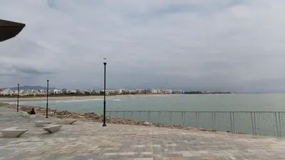 a view of a beach with benches and a fence at COSTA AZUL in Puerto de Sagunto