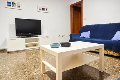 a living room with a blue couch and a table at COSTA AZUL in Puerto de Sagunto