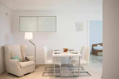 a white dining room with a white table and chairs at SingularStays Alameda II in Valencia