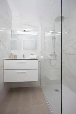 a white bathroom with a shower and a sink at SingularStays Guillem Sorolla in Valencia