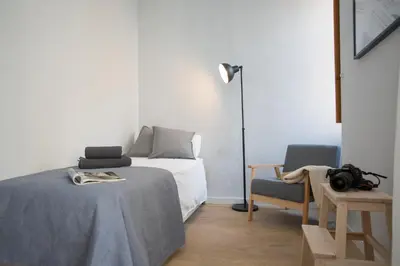 a bedroom with a bed and a lamp and a chair at SingularStays Quevedo II in Valencia