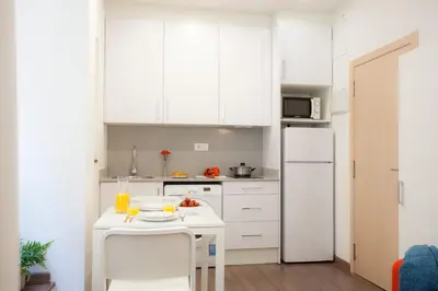 a kitchen with white cabinets and a white refrigerator at SingularStays Salvador II in Valencia