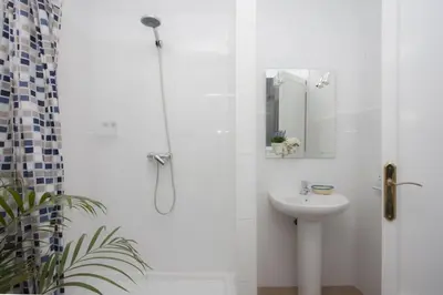 a white bathroom with a shower and a sink at SingularStays SEU V in Valencia