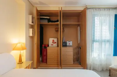 a bedroom with a closet with a bed and a window at RESORT BEACH VALENCIA in Valencia