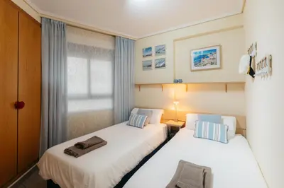 two beds in a room with a window at RESORT BEACH VALENCIA in Valencia