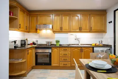 a kitchen with wooden cabinets and a wooden table at SingularStays Clero in Valencia