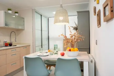 a kitchen with a table with a bowl of fruit on it at SingularStays Oceanografico II in Valencia