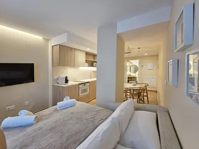 a bedroom with a large bed and a kitchen at Apartamentos Las Ciencias U in Valencia
