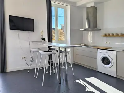 a kitchen with a table and stools in a kitchen at Flats Friends Torres Quart in Valencia