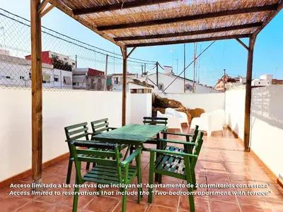 a patio with a green table and chairs on a roof at Flats Friends Torres Quart in Valencia