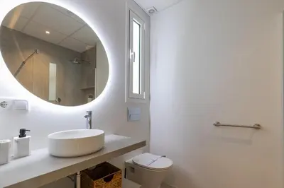a white bathroom with a sink and a mirror at Ca Celieta Beach II in Valencia