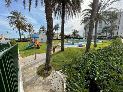 a park with palm trees and a playground at Travel Habitat Playa del Puig in Valencia