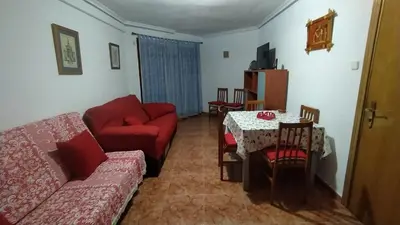 a living room with a red couch and a table at Apartamento Playero in Tavernes de Valldigna