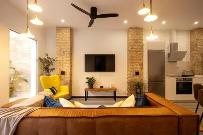 a living room with a couch and a ceiling fan at Portrait Boutique Apartment in Valencia