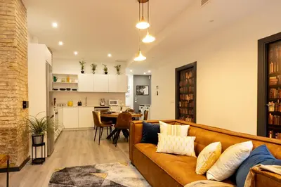 a living room and kitchen with a couch and a table at Portrait Boutique Apartment in Valencia