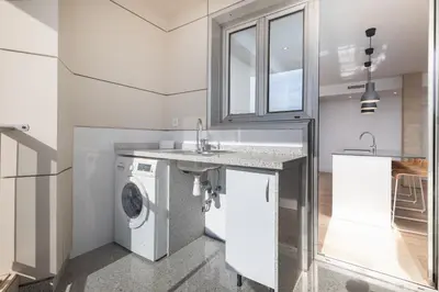 a kitchen with a washing machine and a sink at ApartUP Patacona Deluxe in Valencia