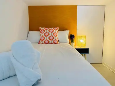 a bedroom with a white bed with a wooden headboard at Modern Designed Loft in Russafa (SOHO) in Valencia