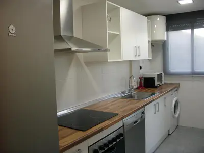 a small kitchen with white cabinets and a sink at Playa y Montaña Faura-Valencia in Faura