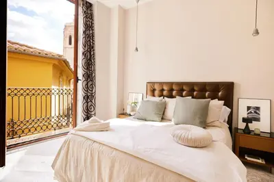 a bedroom with a large bed and a balcony at Citizentral Juristas in Valencia