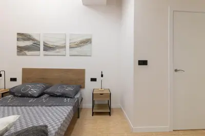 a bedroom with a bed and a night stand at Spacious OCEANOGRAFIC Flats Valencia in Valencia