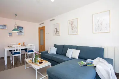a living room with a blue couch and a table at SingularStays El Grao in Valencia