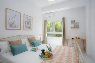 a white bedroom with a bed with a bowl of fruit on it at SingularStays Tinglado in Valencia