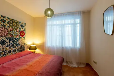 a bedroom with a bed and a large window at Cozy apartment near the center, Torres de Serrano in Valencia