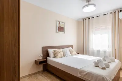 a bedroom with a bed with white sheets and a window at Casa Navajas in Jérica