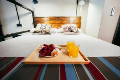 a tray with a plate of fruit and a glass of orange juice at Apartment Ruzafa Roots, 12 min to Centre, Smart TV, Wine in Valencia