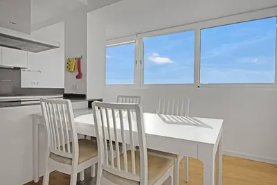 a white kitchen with a white table and chairs at Apartamento atardecer dorado in Valencia