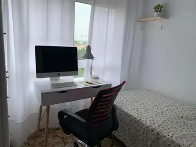 a desk with a computer and a chair next to a bed at Sagunto 2 in Sagunto