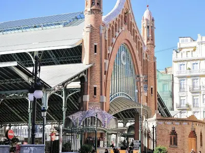 a large brick building with a large clock tower at Travel Habitat Mediterranean Suites in Valencia