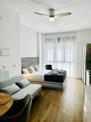 a bedroom with two beds and a couch at Travel Habitat Mediterranean Suites in Valencia