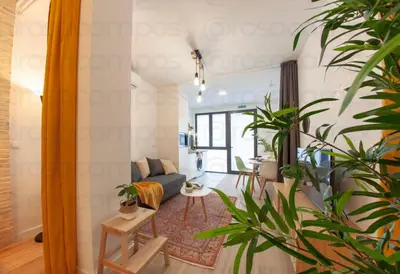 a living room with a blue couch and some plants at RA - Stylish city loft - Walk to the best of Valencia in Valencia