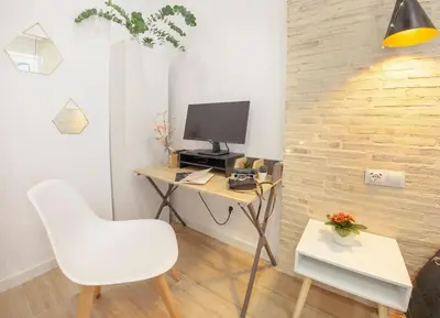 a room with a desk with a computer and a chair at RA - Stylish city loft - Walk to the best of Valencia in Valencia