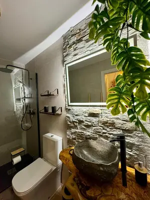 a bathroom with a rock sink and a stone wall at La Casucha de Chulilla in Chulilla