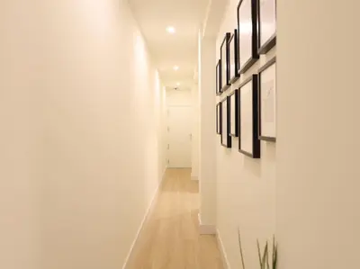 a hallway with white walls and pictures on the wall at Impresionante Apartamento 3 habitaciones by Hometels in Puerto de Sagunto